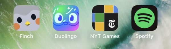 A close-up of a phone screen showing four app icons: Finch, Duolingo, NYT Games and Spotify.
